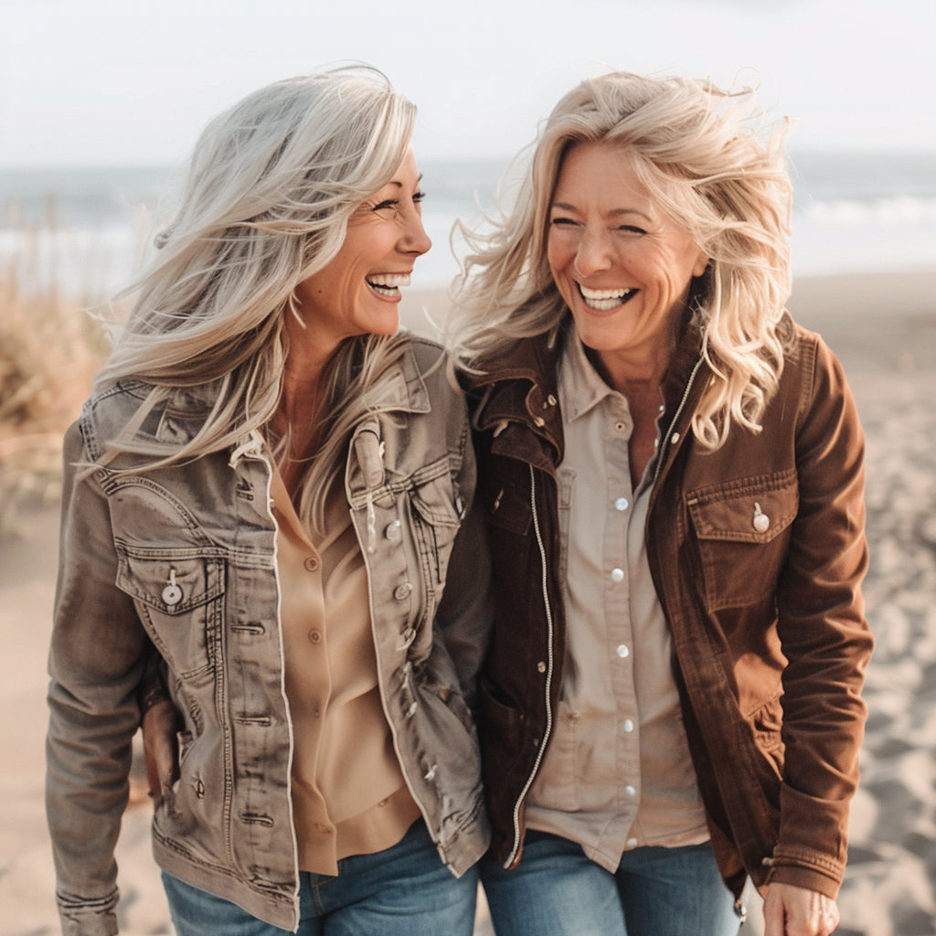 Two female friends walking the coast, loving life and laughing, enjoying a peaceful mind and mood from Wellinda supplements.